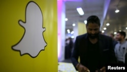 FILE - The logo of messaging app Snapchat is seen at a booth at TechFair LA, a technology job fair, in Los Angeles, California.