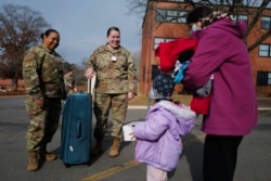 Lt. Col. Andrea Haylock and Tech. Sgt. Ashley Majewski, of the female engagement team, greet an Afghan women and her daughter at Liberty Village on Joint Base McGuire-Dix- Lakehurst, N.J., Dec, 2, 2021.