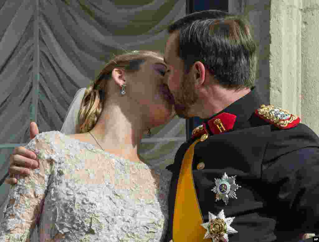 عروس و داماد پس از مراسم ازدواج در بالکن قصر سلطنتی لوکزامبورگ یکدیگر را می بوسند. 