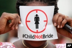 FILE - A woman protests against underage marriages in Lagos, Nigeria, July 20, 2013.