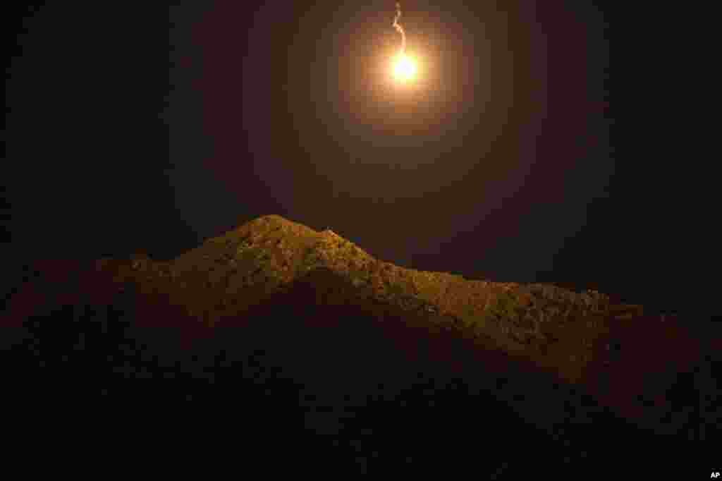 September 14: An illumination round falls over an insurgent fighting position in Kunar province, Afghanistan. (AP Photo/David Goldman)
