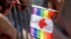 FILE - A rainbow flag with a Canadian emblem is held during a Pride Parade, in Miami Beach, Fla., April 7, 2019.