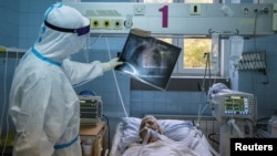 Zdravstveni radnik pored pacijenta obolelog od koronavirusa, u Zemunskoj bolnici u Beogradu, 26. novembra 2020. (Foto: Rojters, Marko Đurica)