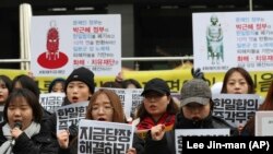 South Korean students shout slogans during a press conference about the 2015 agreement between South Korea and Japan near the Japanese Embassy in Seoul, South Korea, Thursday, Dec. 28, 2017.