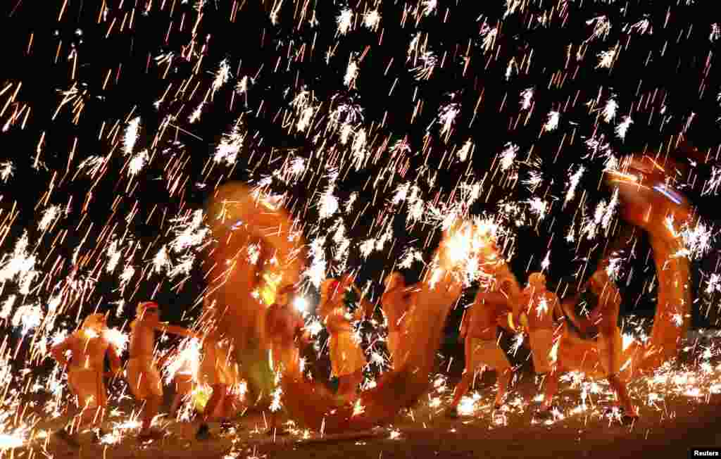 Artists perform a dragon dance under a shower of sparks from molten iron to celebrate the New Year in Suining, Sichuan province, China, Dec. 31, 2016.