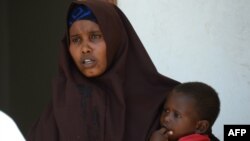Lul Ali Osman, who claimed she was raped by security forces, is seen holding her child at the court house in Mogadishu March 3, 2013.