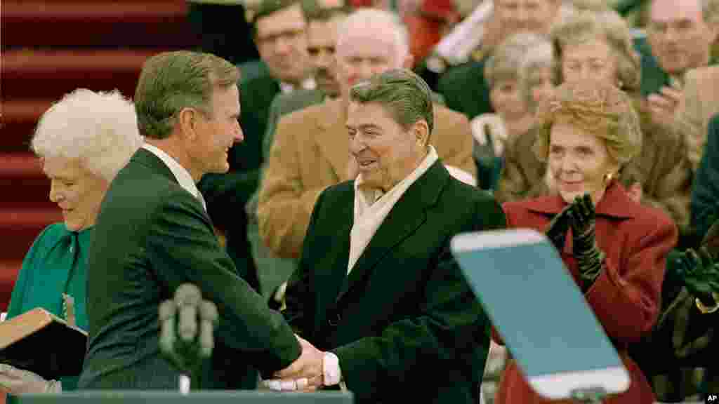 Le président George Bush, à gauche, est félicité par le président sortant Ronald Reagan après que Bush a prêté serment comme le 41ème président des États-Unis sur Capitol Hill à Washington, DC, le vendredi 20 janvier 1989.