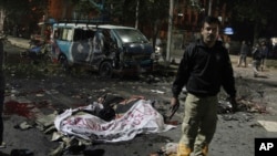 Polisi berjaga-jaga di lokasi pemboman maut di Lahore, Pakistan (13/2). (AP/K.M. Chaudhry)