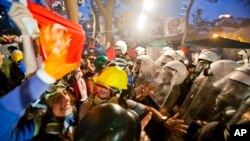 FILE - Protesters try to resist the advance of riot police in Gezi Park in Istanbul, Turkey, June 15, 2013.