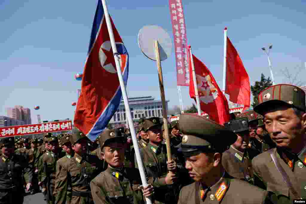 북한군 장병들이 깃발을 들고 13일 평양 여명거리 준공식장으로 향하고 있다.