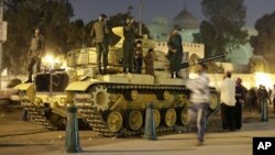 Một người biểu tình Ai Cập chụp hình những đứa con của ông trên một chiếc xe tăng của quân đội Ai Cập, bên ngoài dinh tổng thống ở Cairo, Ai Cập, 8/12/2012
