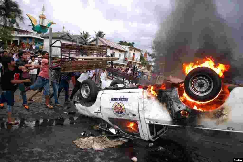 A police vehicle burns following a brief clash at the end of election day in Phnom Penh July 28, 2013.
