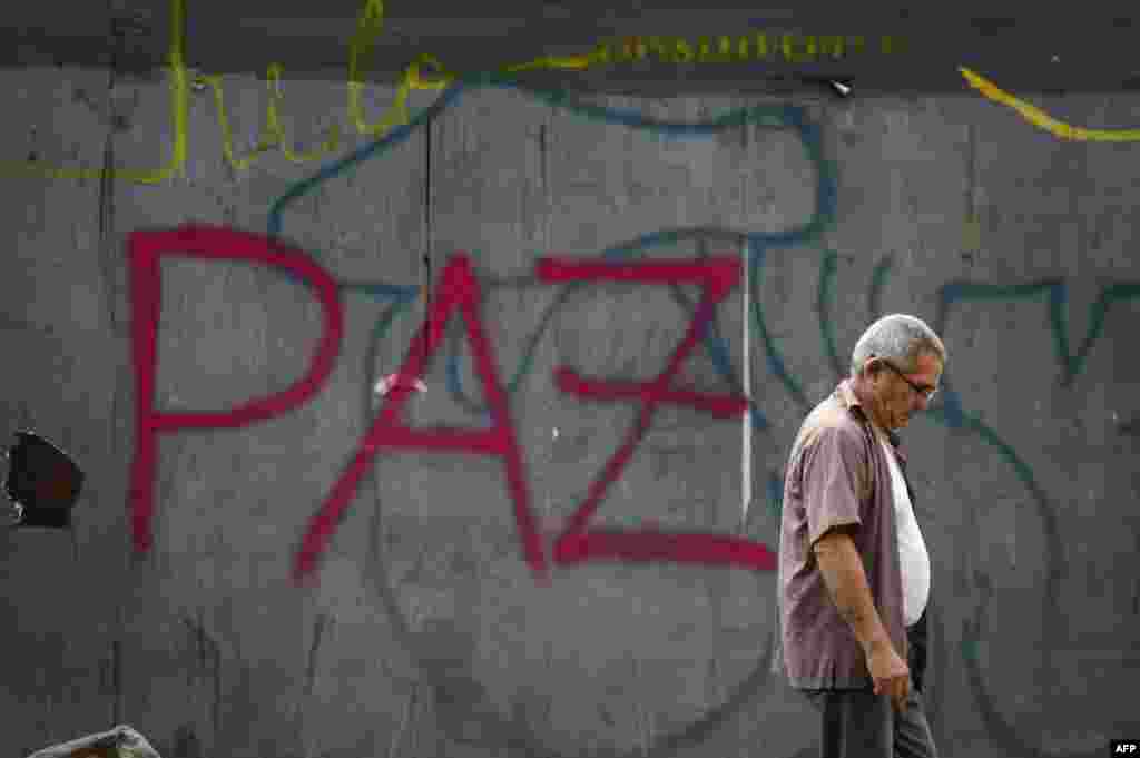 A man walks in front of a graffiti reading "peace" in Caracas, May 1, 2019.