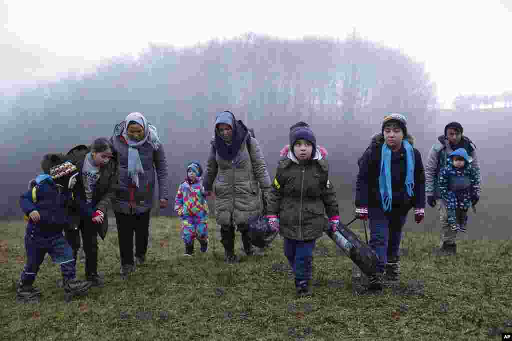 Two Afghan families walk in a clearing after leaving a Croatian forest near the Bosnian town of Velika Kladusa.