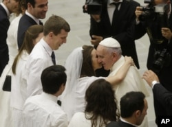 FILE - Pope Francis greets newlyweds during the general audience at the Vatican, Aug. 5, 2015. Pope Francis says divorced Catholics who remarry and their children deserve better treatment from the Catholic church.