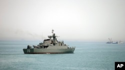 FILE - Iranian warship Alborz, foreground, is seen in the Strait of Hormuz, April 7, 2015. 