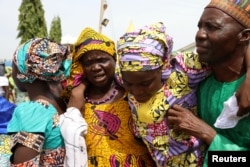 FILE - One of the released 82 Chibok school girls embraces her parents as she reunites with her family in Abuja, Nigeria, May 20, 2017.