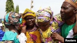 FILE - One of the newly released 82 Chibok school girls embraces her parents as she reunites with her family in Abuja, Nigeria, May 20, 2017. 