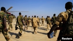 South Sudan army soldiers walk to a military helicopter at Juba international airport, before heading to Bor, Dec. 25, 2013. Amnesty International has accused South Sudan military forces of suffocating 60 men and boys in a container in 2015.