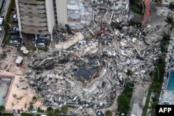 FILE PHOTO - This file aerial view, shows search and rescue personnel working on site after the partial collapse of the Champlain Towers South in Surfside, north of Miami Beach, on June 24, 2021.
