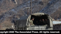 FILE - Azerbaijani soldiers sit in a military truck taking them to their military tent camp, in Kalbajar, Azerbaijan, Dec. 2, 2020. 