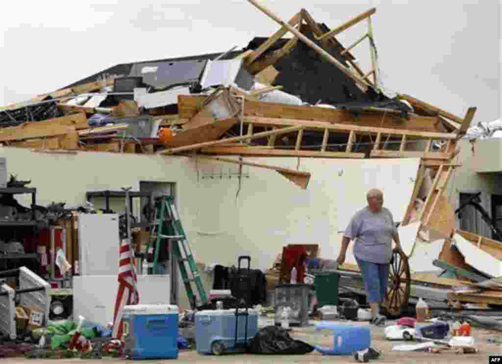 Becky Bass helps carry items out of the house of her son, Richard Bass, on Tuesday, April 26, 2011, in Vilonia, Ark. The town of Vilonia was heavily damaged when a tornado hit during the night. Richard Bass and his family were home when the tornado hit, b