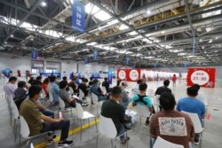 People wait to be vaccinated against COVID-19 during a vaccination session for those from Taiwan, in Nanchang