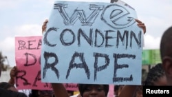 FILE - A woman carries a placard as she shouts a slogan during a "Walk Against Rape" march in Lagos, Nigeria, Oct. 5, 2011.