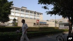 A Foxconn worker walks past a factory belonging to affiliate Foxconn Premier Image Technology (China) Ltd in Foshan in Guangdong province, southern China November 19, 2010.