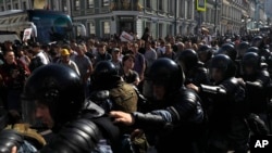 FILE - Police block a street during an unsanctioned rally in the center of Moscow, Russia, July 27, 2019.