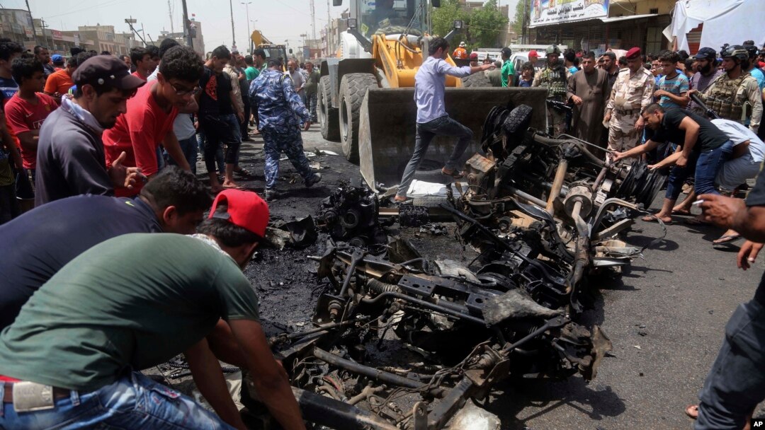Warga membantu petugas membersihkan puing-puing bekas serangan bom dengan bulldozer di Sadr City, Irak (11/5). (AP/Khalid Mohammed)