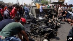 Warga membantu petugas membersihkan puing-puing bekas serangan bom dengan bulldozer di Sadr City, Irak (11/5). (AP/Khalid Mohammed)