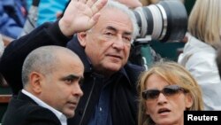 Former International Monetary Fund (IMF) chief Dominique Strauss-Kahn (C) and Myriam L'Aouffir (R) watch the men's singles final match between Rafael Nadal of Spain and compatriot David Ferrer at the French Open tennis tournament at the Roland Garros stad