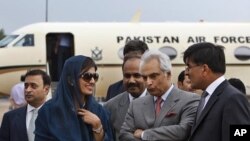 Pakistan’s newly installed FM Hina Rabbani Khar, second left is received by India`s high Commissioner to Pakistan Sharat Sabharwal, right, as Pakistan's high commissioner to India Shahid Malik, second right, looks on at the airport in New Delhi, India, Ju