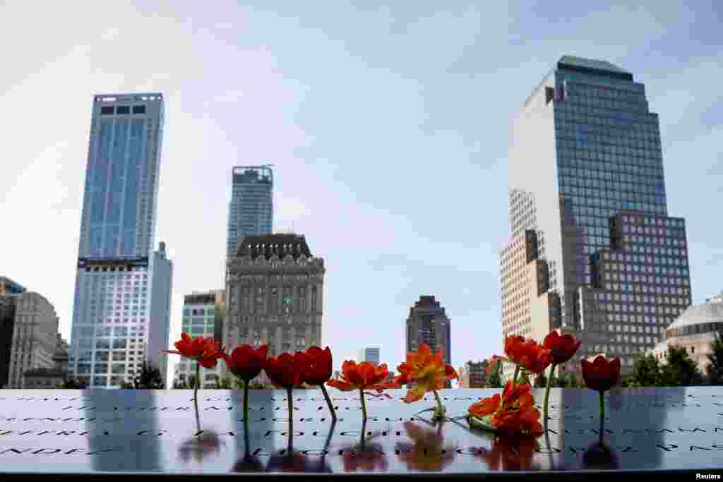 Flowers are placed on names of the victims at the National 9/11 Memorial and Museum during ceremonies marking the 16th anniversary of the attacks in New York.