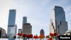 Bunga-bunga diletakkan di nama-nama korban serangan teror 11 September di Peringatan dan Musium Nasional 9/11 di New York , 11 September 2017. 