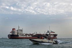 A boat of the Iranian Revolutionary Guard sails next to Stena Impero, a British-flagged vessel owned by Stena Bulk, at Bandar Abbas port, July 21, 2019.