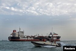 A boat of the Iranian Revolutionary Guard sails next to Stena Impero, a British-flagged vessel owned by Stena Bulk, at Bandar Abbas port, July 21, 2019.