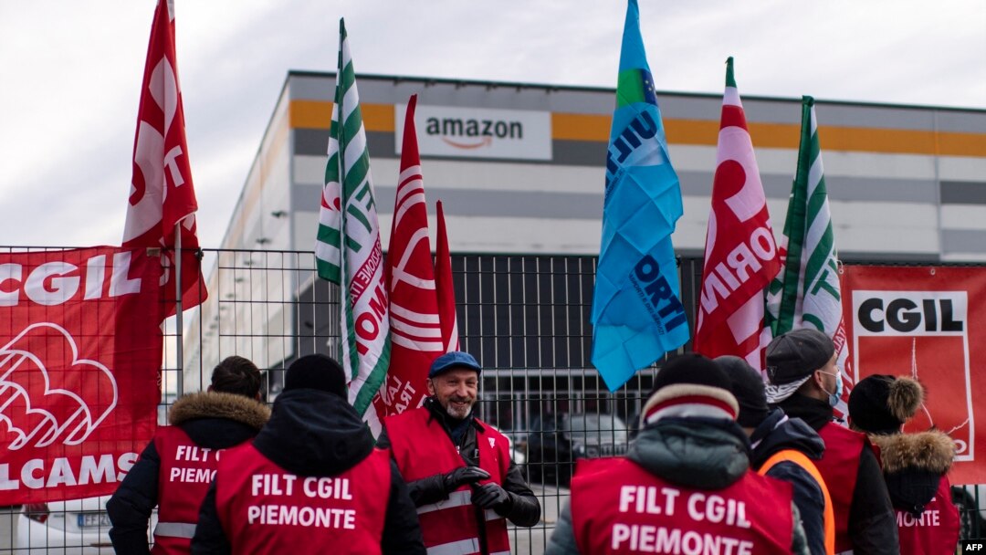 Karyawan Amazon berunjuk rasa di depan kantor perusahaan tersebut di Brandizzo, dekat Turin, Italia, menuntut kondisi kerja yang lebih baik, 22 Maret 2021. (Foto oleh Marco Bertorello / AFP)