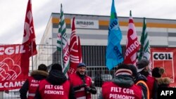 Karyawan Amazon berunjuk rasa di depan kantor perusahaan tersebut di Brandizzo, dekat Turin, Italia, menuntut kondisi kerja yang lebih baik, 22 Maret 2021. (Foto oleh Marco Bertorello / AFP)