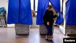 FILE - A voter leaves a polling booth during the U.S. presidential election in Philadelphia, Pennsylvania, Nov. 8, 2016.