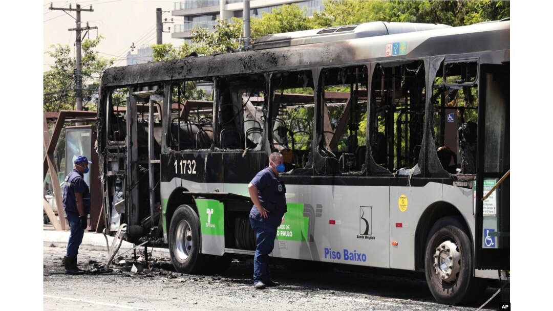 Polisi memeriksa bangkai bus yang sebelumnya terbakar setelah terkena bagian pesawat kecil yang jatuh di sebuah jalan raya di Sao Paulo, Brazil, Jumat, 27 Februari 2025. (Foto: Ettore Chiereguini/AP Photo)
