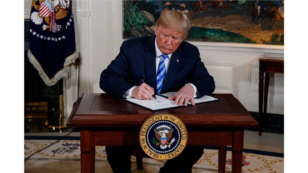 FILE - President Donald Trump signs a Presidential Memorandum on the Iran nuclear deal from the Diplomatic Reception Room of the White House, May 8, 2018.