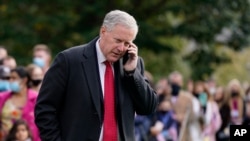 FILE - White House chief of staff Mark Meadows speaks on a phone on the South Lawn of the White House, Oct. 30, 2020.