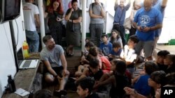 Head of Mission Riccardo Gatti speaks to children aboard the Open Arms ship, moored at the Naples harbor, Italy, Thursday, June 20,2 019.
