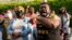 People gather outside the municipal building after at least one Pasquotank County Sheriff's deputy shot and killed a Black man while executing a search warrant, the sheriff's office said, April 21, 2021, in Elizabeth City, NC.