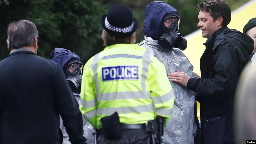 Polisi Inggris mengenakan masker pelindung saat memeriksa lokasi kuburan Luidmila Skripal, istri mantan mata-mata Rusia Sergei Skripal di Salisbury, Inggris (10/3). 