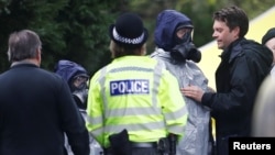 Members of the emergency services in protective suits work at the site of the grave of Luidmila Skripal, wife of former Russian inteligence officer Sergei Skripal, at London Road Cemetery in Salisbury, Britain, March 10, 2018. 