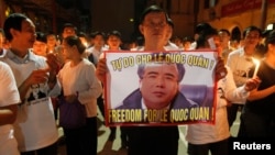 A man holds a poster with the image of lawyer Le Quoc Quan during a mass calling for Quan to be freed at Thai Ha church in Hanoi September 29, 2013. Participants at the mass prayer also called for justice for Quan, a political dissident and pro-democracy 