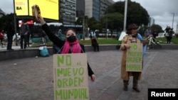 FILE - Anti-quarantine demonstrators wear signs reading "no to the new world order", protesting quarantine measures in Buenos Aires, May 30, 2020. 